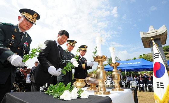 본문 이미지 - 6.25 전쟁 당시 전주형무소에서 학살된 우익 인사들의 넋을 기리는 추모식이 열린 26일 오전 전북 전주시 효자공원묘지에서 참석자들이 헌화를 하고 있다. 이날 추모식에는 이철승 전 헌정회 회장 등 "전주형무소 학살사건" 희생자 유가족들을 비롯해 이형규 전북 정무부지사와 김승수 전주시장 등 각급 유관단체장들이 참석했다.2014.9.26/뉴스1 2014.09.26/뉴스1 ⓒ News1 김대웅 기자