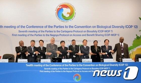 본문 이미지 - 윤상직 산업통상자원부 장관이 29일 강원도 평창 알펜시아 공식회의장에서 열린 '제7차 바이오안전성의정서 당사국회의(COP-MOP 7)'에서 참석자들과 함께 손을 맞잡고 기념촬영을 하고 있다. (산업통상자원부 제공) 2014.09.29/뉴스1 ⓒ News1