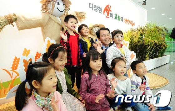 본문 이미지 - 12일 오전 전북 전주시 완산구 농촌진흥청 농업과학관에서 열린 '쌀의 다양한 효능과 건강 지킴이 특별전시회'에서 이양호 농진청장이 견학온 어린이들과 함께 기념사진을 찍고 있다. 이번 전시회는 최고품질벼, 기능성벼, 난장이벼 등 20품종과 흑미, 백미, 적미, 녹미 등 다양한 종자 15종, 컵밥·막걸리·쌀국수·쌀빵 등 쌀로 만든 가공식품 25종, 전국 유명 브랜드 쌀 12종을 전시된다. 2015.10.12/뉴스1 ⓒ News1 김대웅 기자