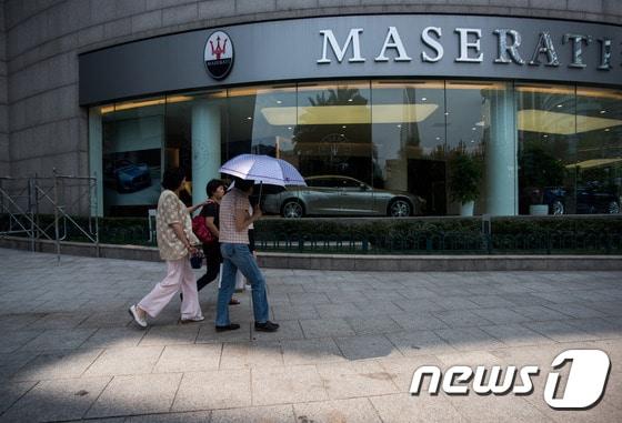 본문 이미지 - 중국인들이 상하이에 소재한 자동차 브랜드 마세라티 매장을 지나고 있다. ⓒAFP=뉴스1