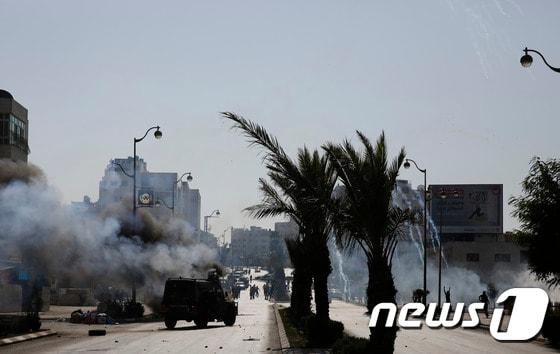 본문 이미지 - 이스라엘군이 라말라 북부 지역의 유대인 정착촌 베이트 알 지역에서 시위를 벌이는 팔레스타인 시위대를 향해 최루가스를 발포하고 있다. ⓒ AFP=뉴스1