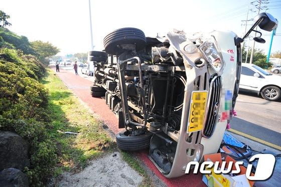본문 이미지 - 18일 오후 제주시 무수천주유소 앞 도로에 25인승 버스가 옆으로 쓰러져 있다. 이 사고로 버스에 타고 있던 13명 중 7명이 119에 의해 인근 병원으로 옮겨져 치료를 받고 있다. 경찰은 정확한 사고 경위를 조사 중이다. 2015.10.18./뉴스1 ⓒ News1 이석형 기자