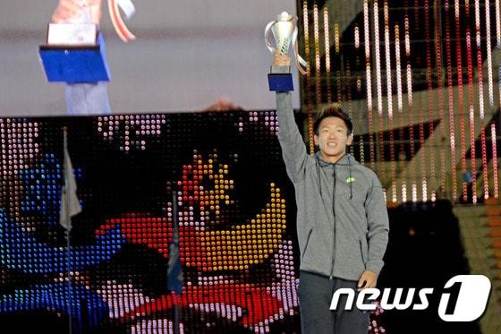 본문 이미지 - 22일 강원 강릉시 종합운동장에서 열린 폐회식에서 대회 최우수선수로 선정된 김국영(23·광주광역시청)이 트로피를 들고 환호하고 있다. 김국영은 이번 대회에서 100m, 200m, 400m 계주, 1600m 계주 등 4관왕을 차지했다. 2015.10.22/뉴스1 ⓒ News1 서근영 기자