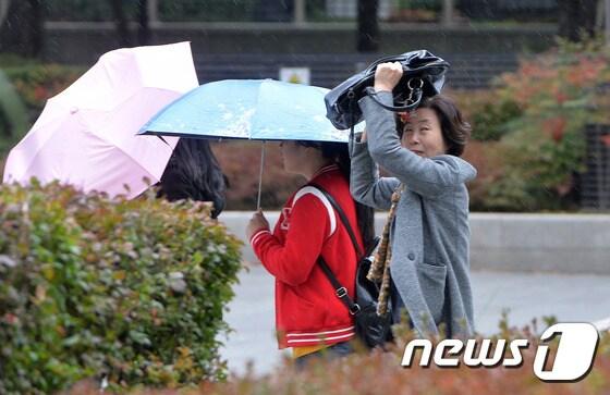 본문 이미지 - 서울 세종로에서 우산을 준비하지 못한 한 시민이 가방으로 갑자기 내린 비를 막으며 발걸음을 재촉하고 있다. 2015.10.29/뉴스1 ⓒ News1 구윤성 기자