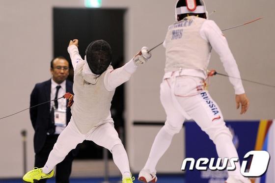 본문 이미지 - 4일 오후 경북 문경 국군 체육부대 실내테니스장에서 열린 '2015 경북문경 세계군인체육대회' 펜싱 남자 플러레 개인종목 결승전에서 정재규(26)가 러시아의 가니프 레날(25)에게 공격을 시도 하고 있다.정재규 선수는 9대 15로 패해 은메달을 목에 걸었다. 2015.10.4/뉴스1 ⓒ News1 이종현 기자