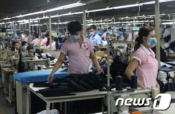 본문 이미지 - 베트남은 저임금과 정부의 적극적 투자유치 노력 등으로 한국의 섬유, 철강, 전기전자 제조업체들의 진출이 활발해지는 등 강력한 글로벌 생산기지로 부상하고 있다. 사진은 베트남으로 생산기지를 이전한 의류 제조업체인 우양통상의 생산라인. (사진공동취재단) 11월15일/뉴스1