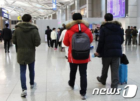 본문 이미지 - 겨울 외투를 입고 출국장으로 들어서고 있는 세 명의 여행객. 겨울 외투는 비좁은 기내에서 본인도 불편하고, 남에게 피해를 줄 수 있다.  2015.11.25. 뉴스1트래블 ⓒ News1travel 조용식 기자