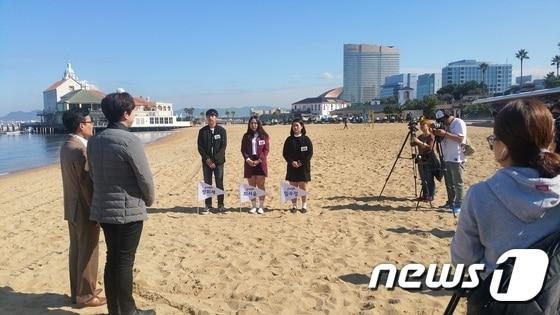 본문 이미지 - 온라인투어가 KBS1 '스카우트 시즌2' 를통해 여행 인재를 채용했다. 후쿠오카 모모치 해변에서 최종합격자 발표를 기다리는 3명의 2차 면접자의 모습과 온라인투어 여행사업본부 일본팀에 입사가 확정된 정희재 학생(가장 왼쪽)의 모습이다. 사진 제공/ 온라인투어 ⓒ News1