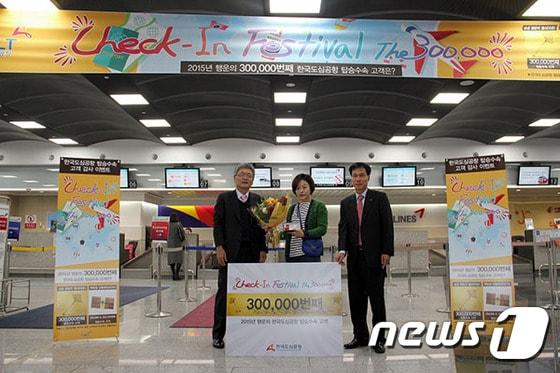 본문 이미지 - 한국도심공항 이종철 대표이사(왼쪽 )가 연간 누적 탑승수속 30만 번째 당첨자와 기념사진을 찍고 있다. 주인공은 정보배(33)씨로 후쿠오카로 출국하기 위해 한국도심공항을 방문했다. 사진 제공/ 한국도심공항 ⓒ News1