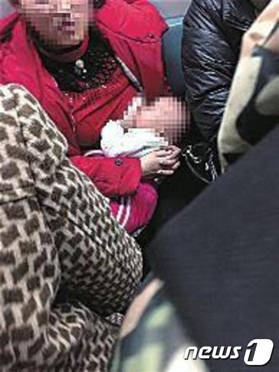 본문 이미지 - 한 여성이 지하철에서 모유를 수유하고 있는 장면을 찍은 사진이 확산되면서 이를 둘러싸고 논란이 가중됐다. (사진출처:환구망)ⓒ뉴스1