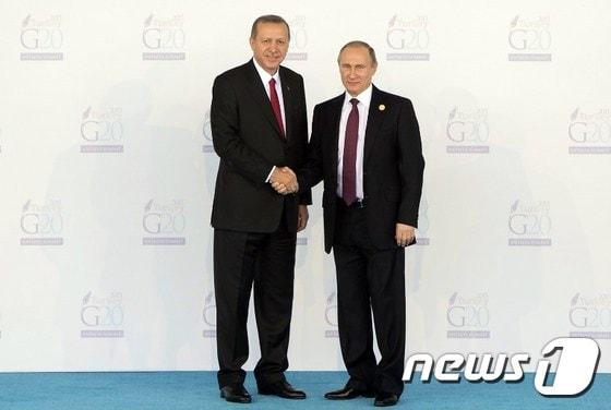 본문 이미지 - 지난달 터키에서 열린 주요 20개국(G20) 정상회의에서 손을 맞잡은 레제프 타이이프 에르도안 터키 대통령(왼쪽)과 블라디미르 푸틴 러시아 대통령. 키 차이가 꽤 난다.ⓒ AFP=뉴스1