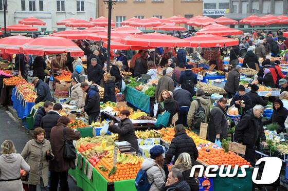 본문 이미지 - ‘꽃보다 누나’에 소개된 돌라체 시장은 신선한 야채와 과일을 판매하는 곳이다. 노상을 수놓은 빨강 우산은 크로아티아의 전통 의상 일부로 사용된 셰스틴스키 우산이며, 기념품으로도 팔리고 있다. 뉴스1트래블 ⓒ News1 travel 조용식 기자