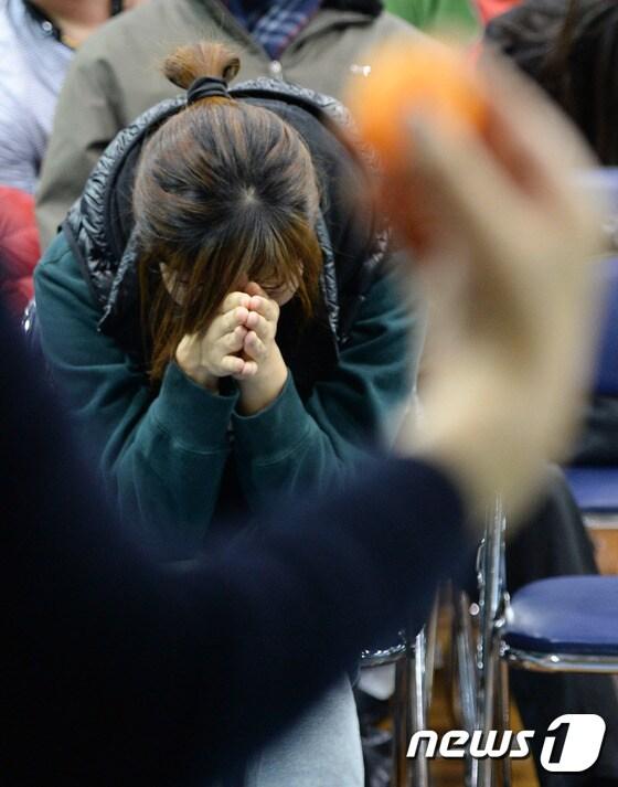 본문 이미지 - 유치원 원아 추첨식에서 한 학부모가 당첨되기를 기도하고 있다. (자료사진)ⓒ News1 DB