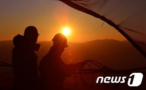 본문 이미지 - 새벽 서울 송파구 잠실 롯데월드타워에서 일하는 근로자들 머리위로 붉은 태양이 떠오르고 있다. ⓒ News1 손형주 기자