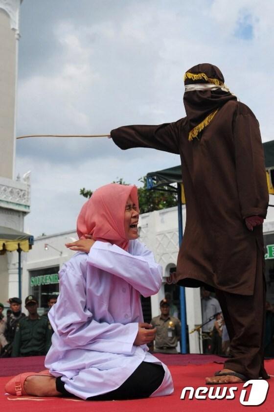 본문 이미지 - 회초리형 받는 인니 여대생 누르 엘리타(20).ⓒ AFP=뉴스1