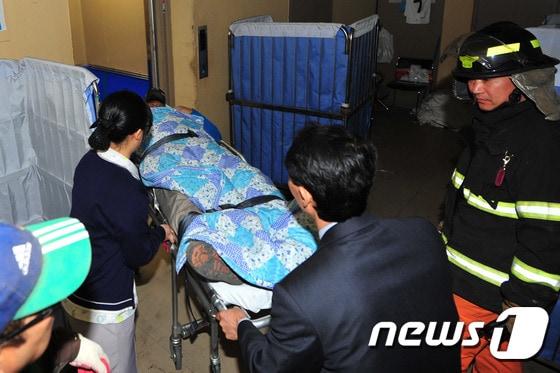 본문 이미지 - 14일 오후 3시15분쯤 경북 경주시 마동 코오롱 호텔 지하 1층에서 보온제 교체 작업 중 다량의 CO2 가스가 누출돼 이를 흡입한 근로자 7명 중 1명이 사망하는 사건이 발생했다. 119구조대원들이 근로자를 병원으로 이송하고 있다. 2015.2.14/뉴스1 ⓒ News1 최창호 기자