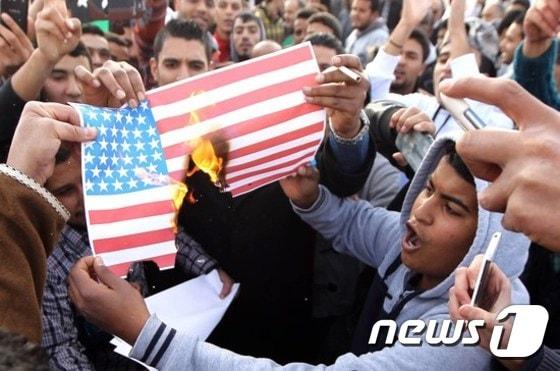 본문 이미지 - 리비아인들이 국제사회의 무기 금수 조치 해제를 요구하면서 미국 국기를 태우고 있다. ⓒAFP=뉴스1