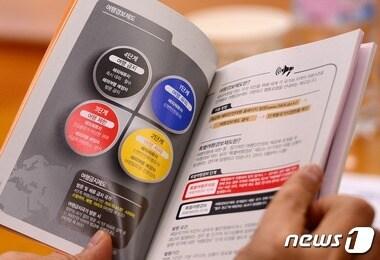 본문 이미지 - 25일 오후 서울 세종로 외교부청사에서 열린 여행사 대상 안전간담회에서 여행사 관계자가 외교부 여행경보제도 안내책을 살펴보고 있다. 외교부는 이번 회의에서 여행사에 위험 지역으로 가는 여행 상품 판매를 자제할 것을 요청하고 안전 유의사항을 전파했다. 현재 외교부는 국가별 안전 수준을 4단계(여행유의·여행자제·여행제한·여행금지)로 알려 주는 여행경보 제도를 운영하고 있다. 2015.2.25/뉴스1 ⓒ News1 박지혜 기자