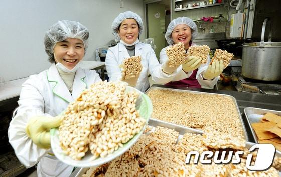 본문 이미지 - 설 명절을 앞둔 6일 오전 전북 완주군 봉동읍 "미소공주" 유경애 대표(왼쪽)와 직원들이 과즐을 만들고 있다. 과즐이란 "과줄"의 옛말로 꿀과 기름을 섞어 기름에 지진 과자를 말한다.2015.2.6/뉴스1 ⓒ News1 김대웅 기자