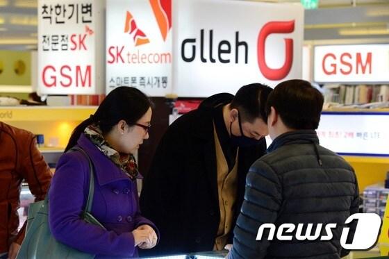 본문 이미지 - 서울 시내 한 휴대전화 판매매장에서 점원이 손님에게 신규가입 절차를 안내하고 있다. 2015.3.12/뉴스1 ⓒ News1 정회성 기자