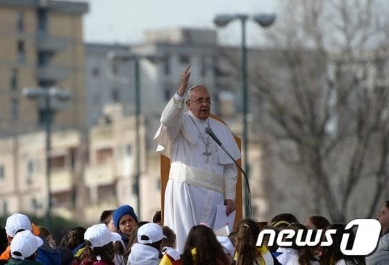 본문 이미지 - 21일(현지시간) 이타리아 3대 마피아 &acute;카모라&acute;의 근거지인 나폴리를 찾은 프란치스코 교황이 스캄피아에서 아이들에 둘러 싸인 채 메시지를 전하고 있다.ⓒ AFP=뉴스1