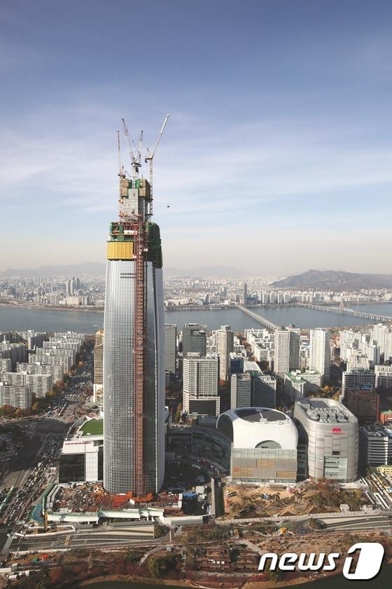 본문 이미지 - 서울 잠실에 건설 중인 제2롯데월드 &acute;롯데월드타워&acute;. 123층, 555m높이로 건설된다. 24일 100층을 돌파했다.ⓒ News1