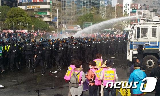 본문 이미지 - 24일 민주노총 대구본부 노조원들이 수성구 범어동 범어네거리에서 새누리당 대구시당 방향으로 행진을 시도하자 경찰이 물대포를 쏘며 시위대를 해산시키고 있다. 이날 노조원들은 범어네거리를 1시간 동안 점거한 채 경찰과 대치했다.2015,4.24/뉴스1 ⓒ News1 배준수 기자