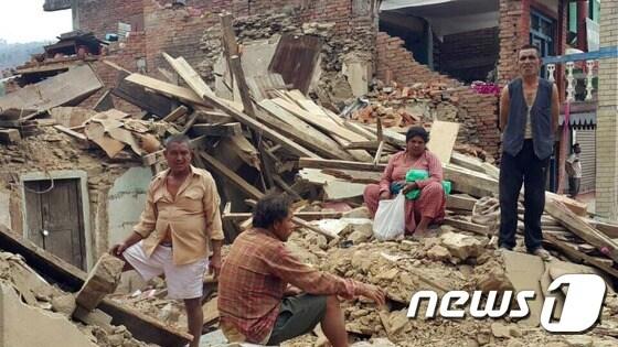 본문 이미지 - 7.8 규모의 강진으로 도시 대부분이 무너진 네팔 신두팔촉 시파갓 마을 주민들이 28일(현지시간) 무너진 집 잔해 위에 망연자실 앉아있다. 국제구호단체 기아대책은 네팔 카트만두로 파견된 긴급 구호팀이 카트만두에서 60km 떨어진 신두팔촉 지역을 방문해 본격 활동을 시작했다고 29일 밝혔다. (기아대책 제공) 2015.4.29/뉴스1 ⓒ News1 조희연 기자