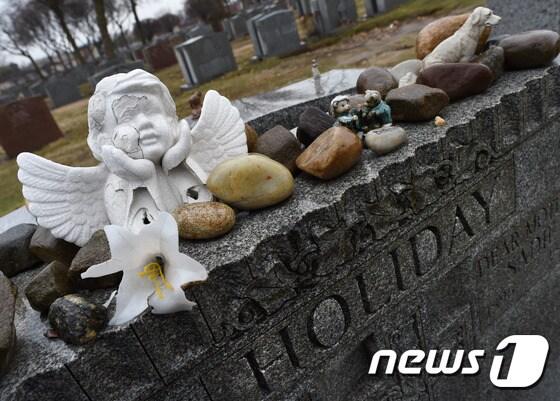 본문 이미지 - 뉴욕에 위치한 빌리 홀리데이의 묘비위에 추모객들이 가져놓은 돌과 꽃이 놓여있다. ⓒAFP=News1