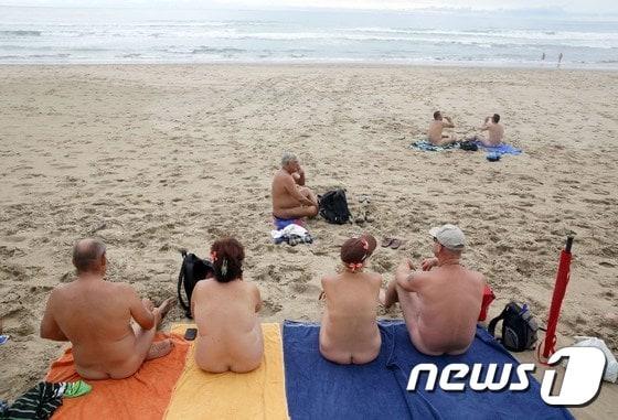 본문 이미지 - 4일(현지시간) 개장한 남아프리카공화국 음펜자티 누드 비치를 찾은 관광객들이 옷을 벗은 채 일광욕을 즐기고 있다. 음펜자티는 아프리카 첫 공인 누드 비치이다.ⓒ AFP=뉴스1