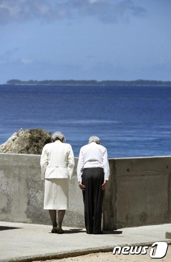 본문 이미지 - 남태평양 팔라우를 방문중인 아키히토 일왕 부부가 9일 2차 대전 격전지 중 하나였던 페리류섬에 있는 전몰자 위령비에 헌화한 뒤에 치열한 전투가 벌어졌던 또 다른 섬을 향해 배례했다. ⓒ AFP=News1