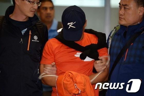 본문 이미지 - 안양 환전소 살인사건 및 필리핀 연쇄 납치사건 피의자 김성곤이 한-필리핀 범죄인인도조약에 따라 13일 오후 인천국제공항을 통해 국내로 송환되고 있다. 김성곤은 공범 최세용, 김종석 등과 2007년 경기도 안양시 한 사설환전소에서 여직원을 살해한 뒤 필리핀으로 도주해 2008년부터 2012년까지 한국인 관광객 등을 상대로 납치·강도 등의 범행을 벌인 혐의를 받고 있다. 법무부는 불법총기소지 등의 혐의로 필리핀 감옥에서 복역 중인 김성곤을 현지 형 집행을 중지한 뒤 국내로 이송해 수사와 재판을 받도록 하는 임시인도 방식으로 이날 송환했다. 2015.5.13/뉴스1 ⓒ News1 정회성 기자