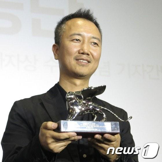 본문 이미지 - 임흥순 작가가 베니스 비엔날레 미술전 은사자상을 들고 포즈를 취하고 있다.  ⓒ News1