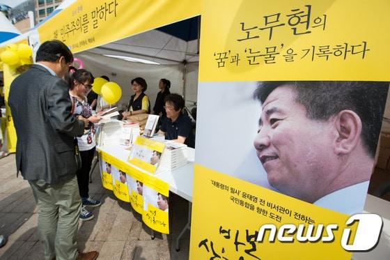 본문 이미지 - 오는 23일 노무현 전 대통령 서거 6주기를 앞두고 17일 서울광장에서 열린 추모행사 "5월 민주주의 시민축제 그대에게"에 참석한 시민들이 고 노무현 전 대통령 관련 도서를 살피고 있다. 2015.5.17/뉴스1 ⓒ News1 유승관 기자