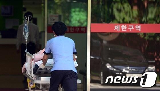 본문 이미지 - 의료진이 한 환자를 병원 내로 이송하고 있다. /뉴스1 ⓒ News1 양동욱 기자