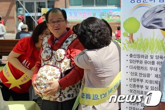 본문 이미지 - 5일 &acute;청양어린이날 기념행사&acute;앞서 이석화 청양군수가 의료원에서 마련한 다자녀출산 홍보 부수에서 임산부 체험을 하고 있다.ⓒ News1조문현 기자