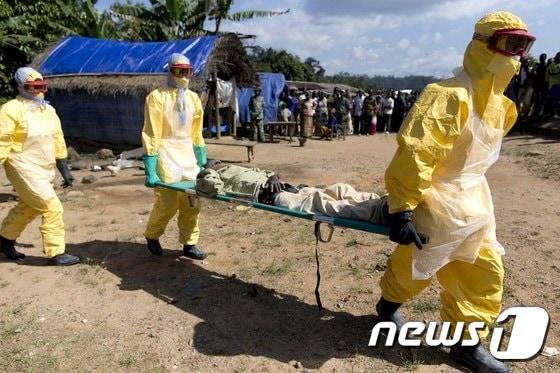 본문 이미지 - 기니 보건당국 직원들이 에볼라 바이러스 감염자를 들 것에 실어 이송하고 있다. ⓒ AFP=뉴스1