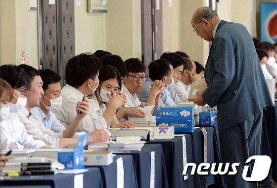 본문 이미지 - 12일 오전 서울 서초구 서울중앙지방법원 3별관 제1호 법정에서 열린 팬오션 변경회생계획안 결의 관계인집회에서 소액주주들이 회생채권 순번 확인을 하고 있다. 2015.6.12/뉴스1 ⓒ News1 신웅수 기자