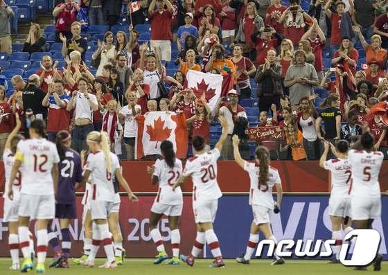본문 이미지 - 캐나다 여자 대표팀 선수들이 16일(한국시간) 캐나다 몬트리올에 위치한 올림픽 스타디움에서 열린 네덜란드와의 2015 FIFA 캐나다 여자 월드컵 A조 3차전에서 1-1로 비기며 16강 진출에 성공한 뒤 팬들에게 인사하고 있다. ⓒ AFP=News1