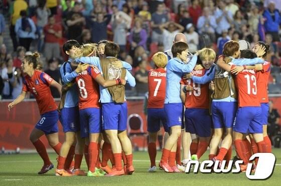 본문 이미지 - 18일 오전(한국시간) 캐나다 오타와 랜스다운 경기장에서 열린 2015 캐나다 여자월드컵 조별리그 마지막 경기에서 스페인을 2:1로 누르고 16강에 오른 대한민국 선수들이 경기 종료 휘슬이 울린 후 서로 얼싸 안으며 기뻐하고 있다. 2015.6.18 로이터/뉴스1 ⓒ News1 이종덕 기자