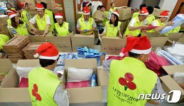 본문 이미지 - 지난달 23일 오후 경기도 수원시 팔달구 우만종합사회복지관에서 경기사회복지공동모금회 주최로 열린 6월의 크리스마스에서 관계자들과 자원봉사자들이 저소득층에게 전달할 선물 박스를 포장하고 있다. 6월의 크리스마스 행사는 무더위에 취약한 도내 독거노인, 거동불편자 등 저소득가정이 시원하고 건강한 여름을 보낼 수 있도록 여름용품을 지원하는 사업이다. 2015.6.23/뉴스1 ⓒ News1 이재명 기자