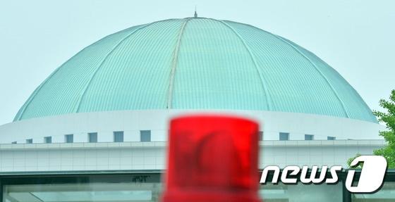본문 이미지 - 박근혜 대통령이 25일 국회법 개정안에 대한 거부권을 행사하면서 야당이 모든 국회의 의사일정 중단을 선언하는 등 국회가 혼란에 휩싸이고 있다. 25일 붉은색 경광등 뒤로 국회의사당의 돔이 보인다. 2015.6.25/뉴스1 ⓒ News1 김명섭 기자