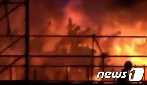 본문 이미지 - 27일(현지시간) 대만 &acute;포모사 펀 코스트&acute; 워터파크에서 발생한 화재 현장의 모습. 입장객들이 발화성 물질인 컬러 파우더에 불이 붙으면서 순식간에 화염에 휩싸인 무대 인근을 벗어나고자 뛰어나가고 있다. ⓒ AFP=뉴스1