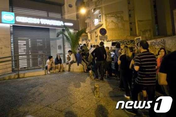 본문 이미지 - 그리스 아테네 시민들이 29일 새벽 ATM에서 예금을 인출하기 위해 은행 밖에서 대기하고 있다. ⓒ AFP=News1