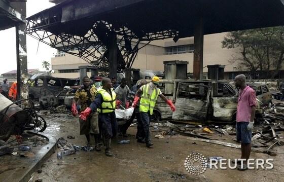 본문 이미지 - 3일(현지시간) 밤 폭발사고가 발생한 가나 수도 아크라의 주유소에서 현지 소방관이 구조작업을 진행 중이다. ⓒ 로이터=뉴스1