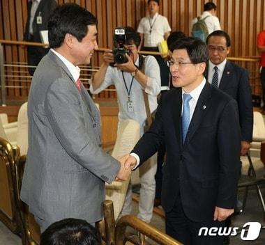 본문 이미지 - 황교안 국무총리 후보자가 지난 9일 서울 여의도 국회에서 열린 인사청문회에서 오전 회의를 마치고 정회가 선포된 뒤 청문회장을 찾은 이종걸 새정치민주연합 원내대표와 악수를 나누고 있다. 황 후보자와 이 원내대표는 경기고 72회 동기로 '40년 지기'다. 2015.6.9/뉴스1 ⓒ News1 오대일 기자