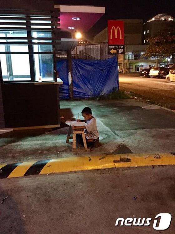 본문 이미지 - 홈리스 필리핀 소년 다니엘 카브레라가 한밤중 맥도날드 매장 불빛에 의존해 공부하고 있다. ⓒ AFP=뉴스1