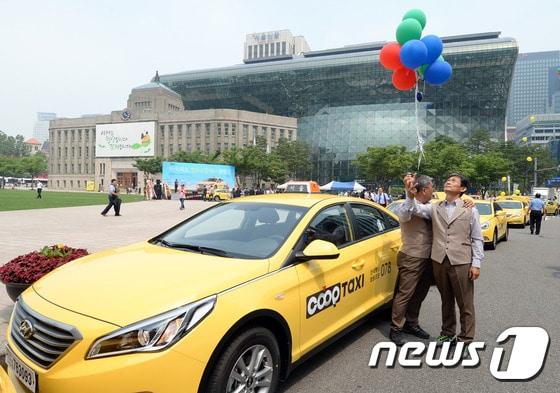 본문 이미지 - 14일 오전 서울 서울광장에서 열린 한국택시협동조합 출범식에서 택시기사들이 첫 운행에 앞서 축하 풍선을 날리고 있다. 2015.7.14 ⓒ News1 신웅수 기자