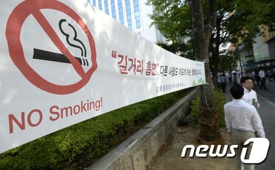 본문 이미지 - 15일 서울시내 거리에 길거리 흡연 금지 안내문이 붙어있다. 보건복지부는 지난해 9월 담뱃값 2000원 인상안이 포함된 금연종합대책 발표 이후 1년여 기간 동안 성인남성 흡연율이 5.8% 하락했다고 밝혔다. 복지부는 오는 2020년까지 흡연자의 대부분을 차지하는 성인남성 흡연율을 29% 이하로 떨어트리는 정책을 추진 중이다. 2015.7.15/뉴스1 ⓒ News1