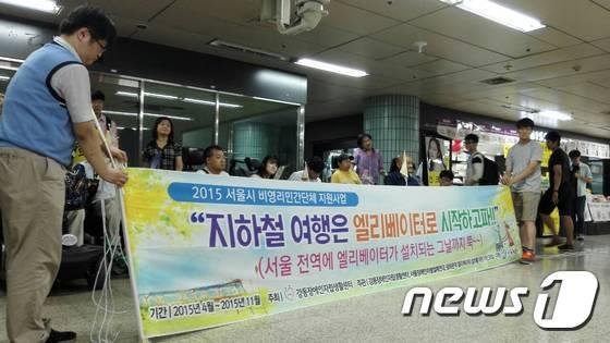 본문 이미지 - 장애인 단체 회원들이 지난달 21일 "지하철 역사 내 엘리베이터 설치와 장애인 이동권 보장"을 촉구하는 퍼포먼스를 열고 있다. 뉴스1 ⓒ News1